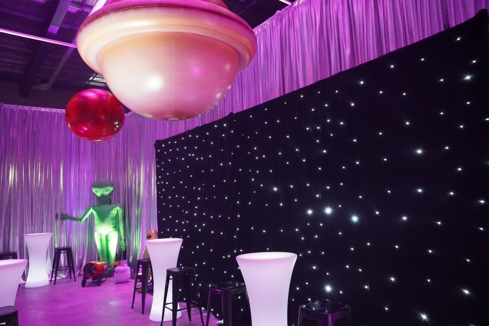 star cloth, illuminated furniture and inflatable planet at space themed party