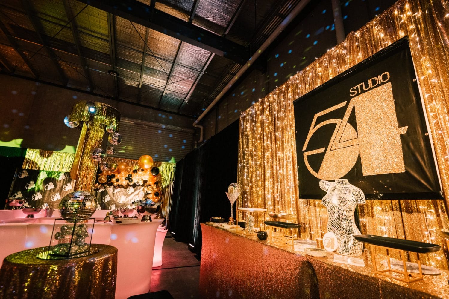 glamorous gold studio 54 themed party with themed props and gold draping