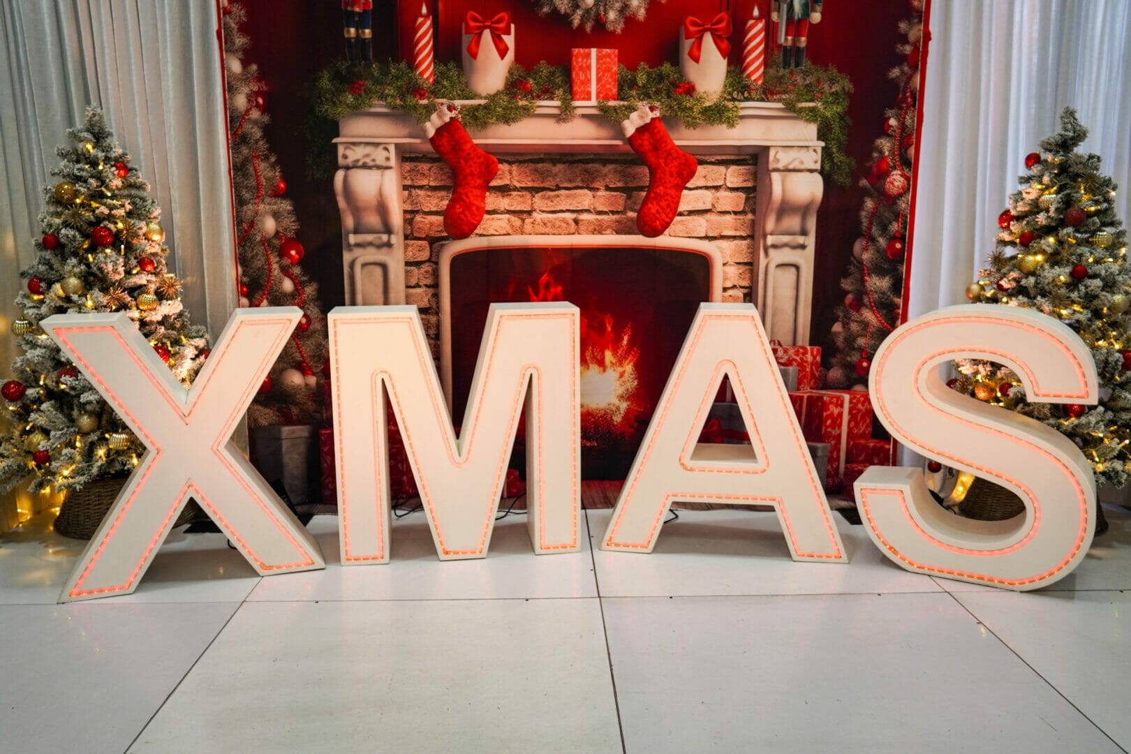 christmas themed backdrop and large light up letters spelling out XMAS