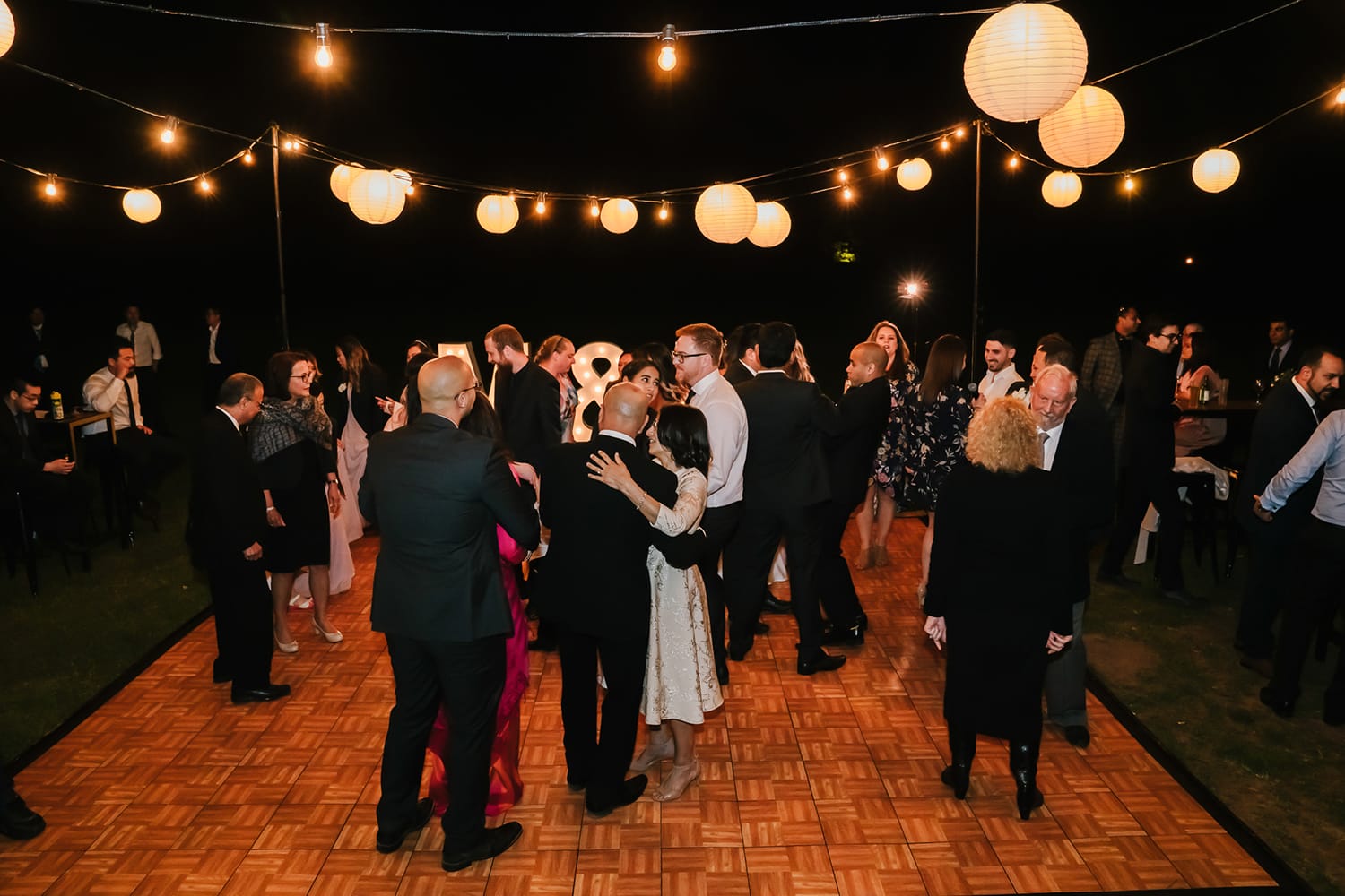 dancing on an outdoor wedding dance floor with overhead festoon lanterns in melbourne