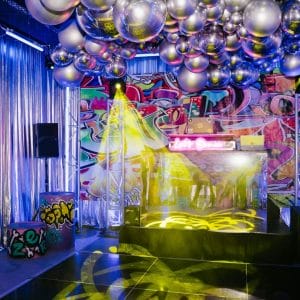 Graffiti party dance floor area, balloon garland, party lights, dj booth