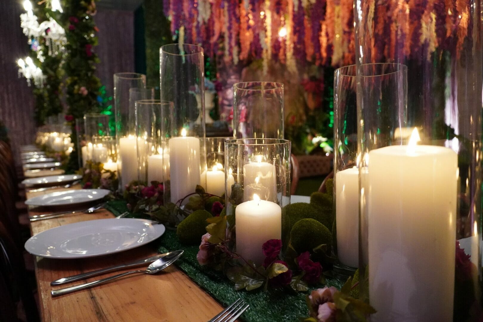 Glass vases and candles in enchanted garden themed setup