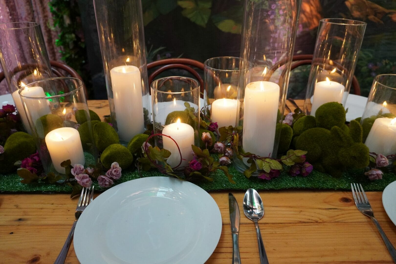 glass vases, candles, themed props, dinnerware in an enchanted garden themed event