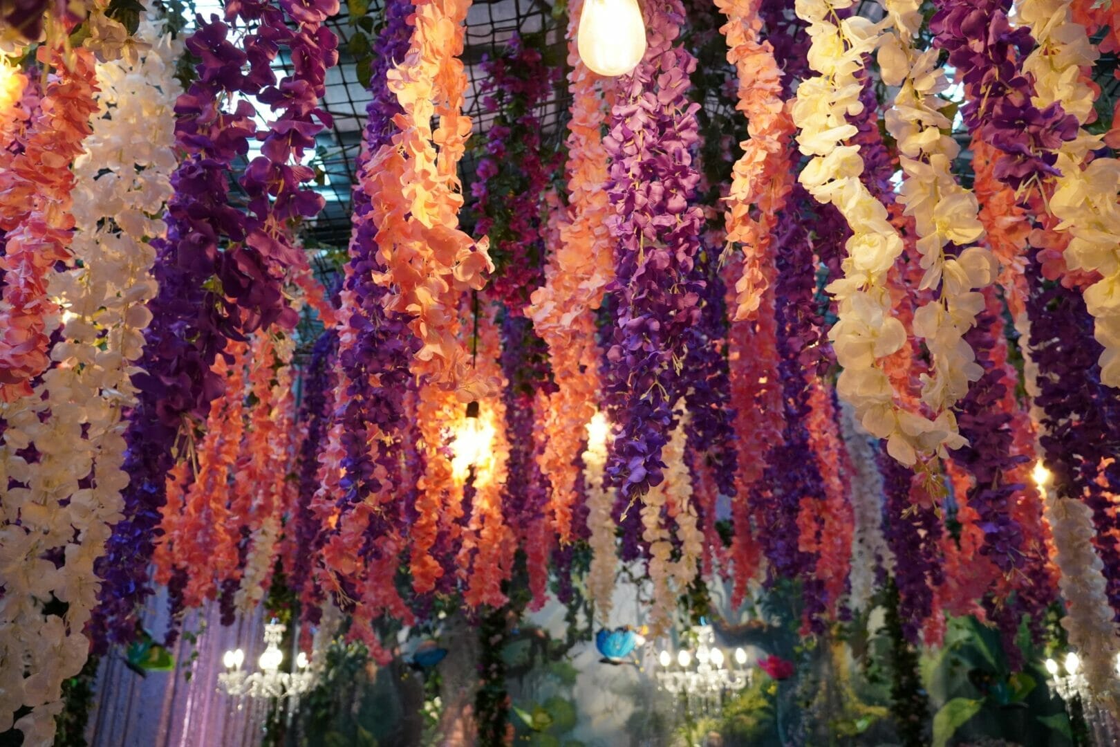 hanging artificial flowers in an enchanted garden themed event