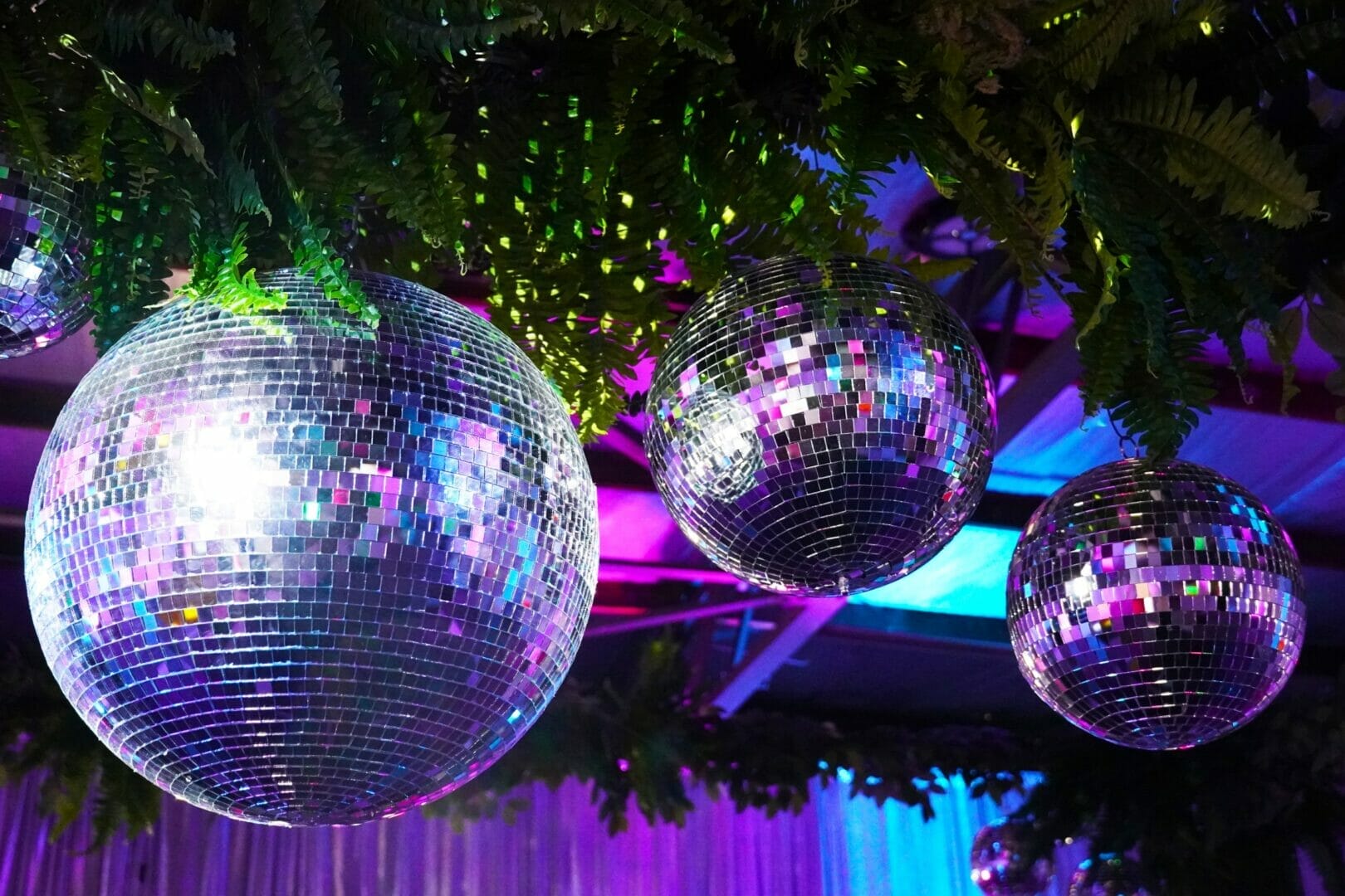 silver mirror balls and greenery at neon disco party theme