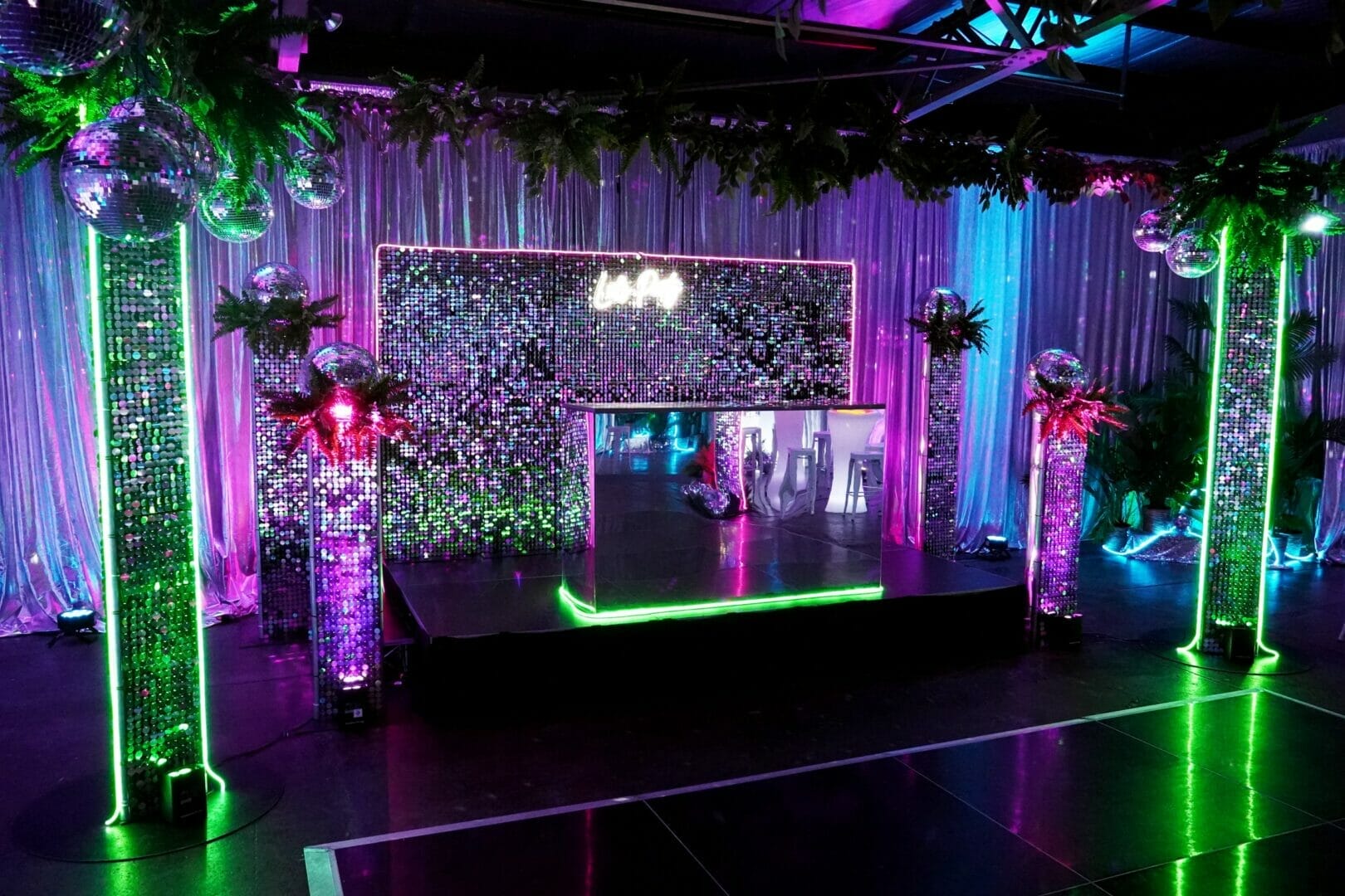 sequin panels, silver acrylic bar, neon sign, dj area and black dance floor