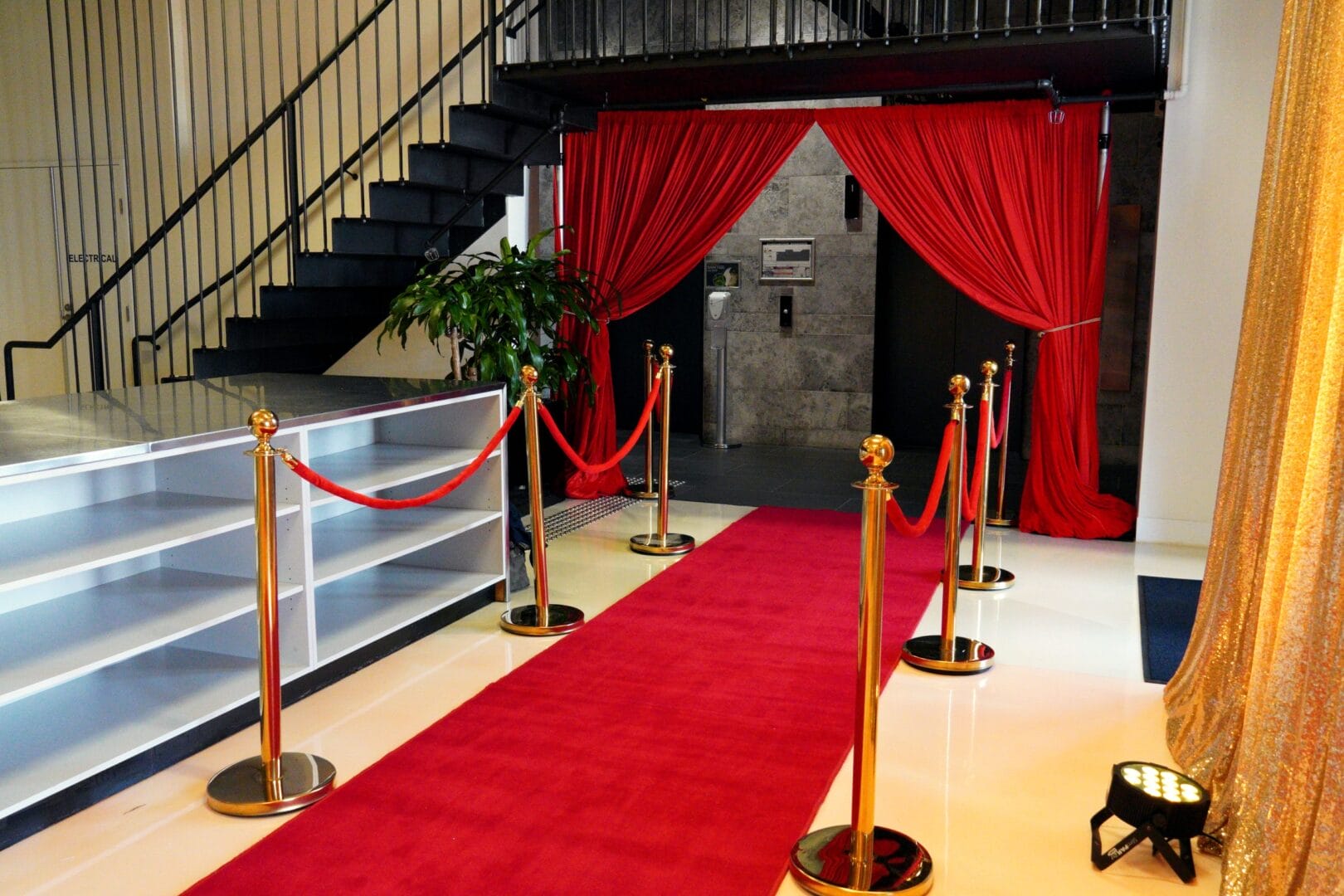 red carpet and bollards with red and gold drape