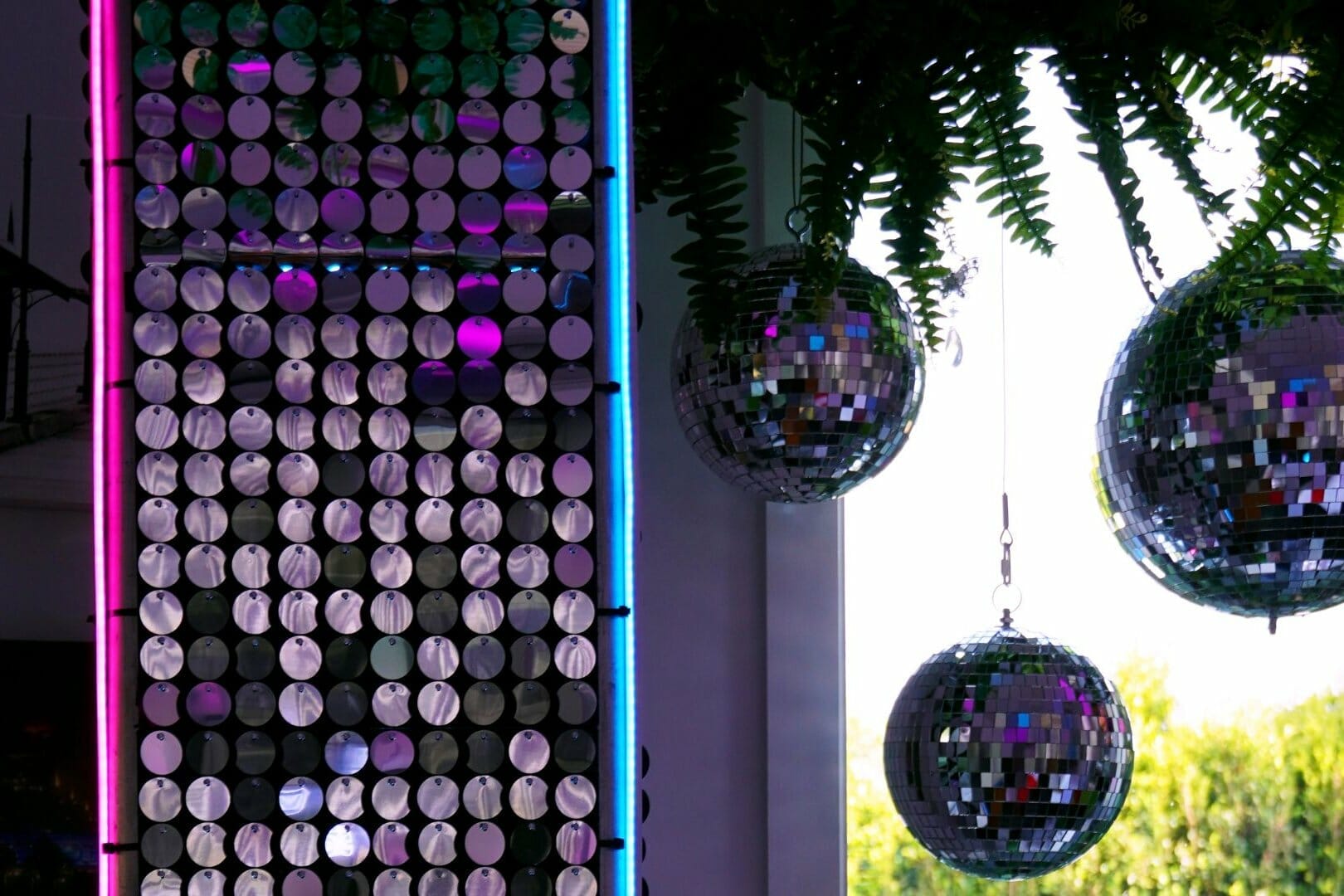 silver sequin panels, mirror balls, neon strips, greenery