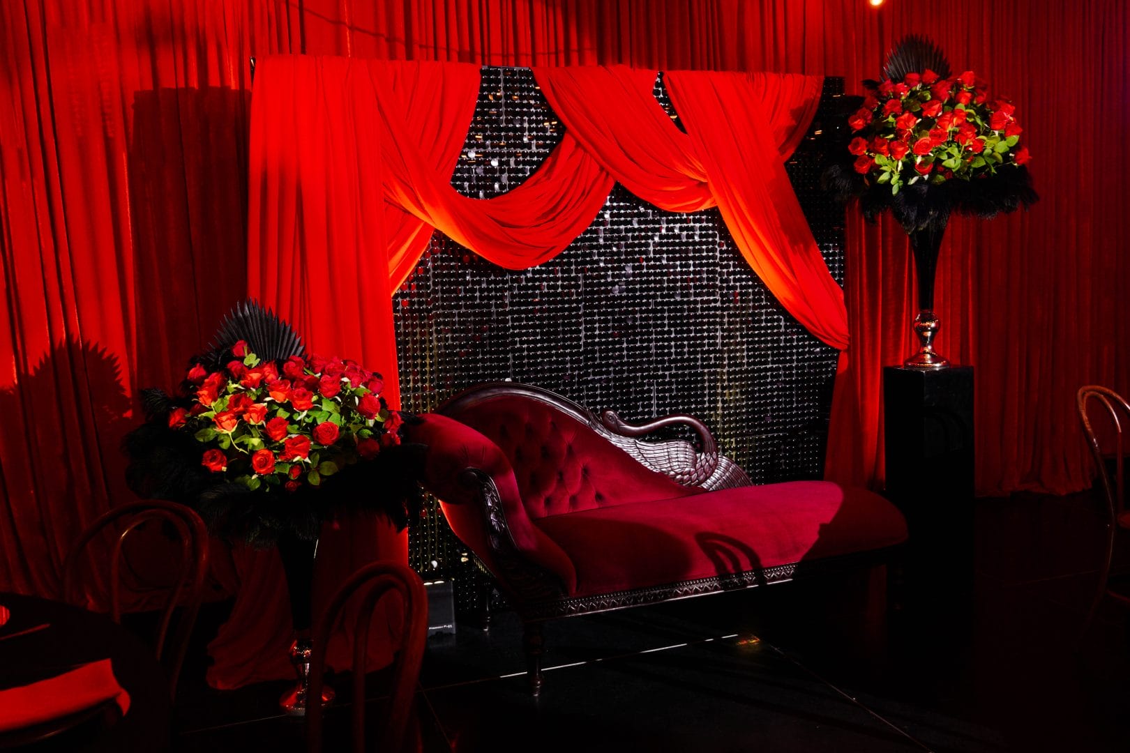 black sequin panel backdrop, red velvet drape, roses, red loveseat