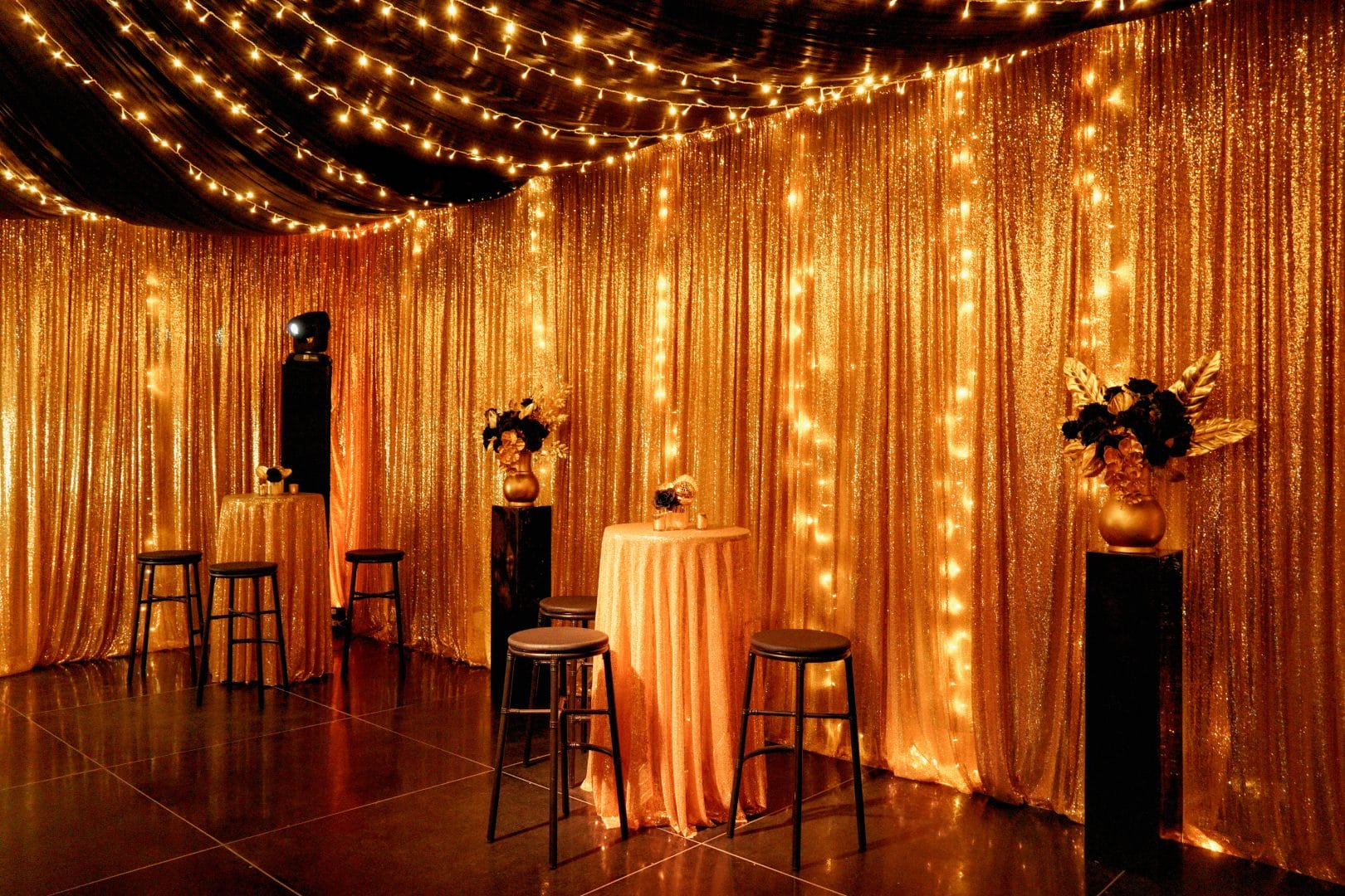 bar tables and chairs, gold sequin drape, fairy lights, floral centrepieces