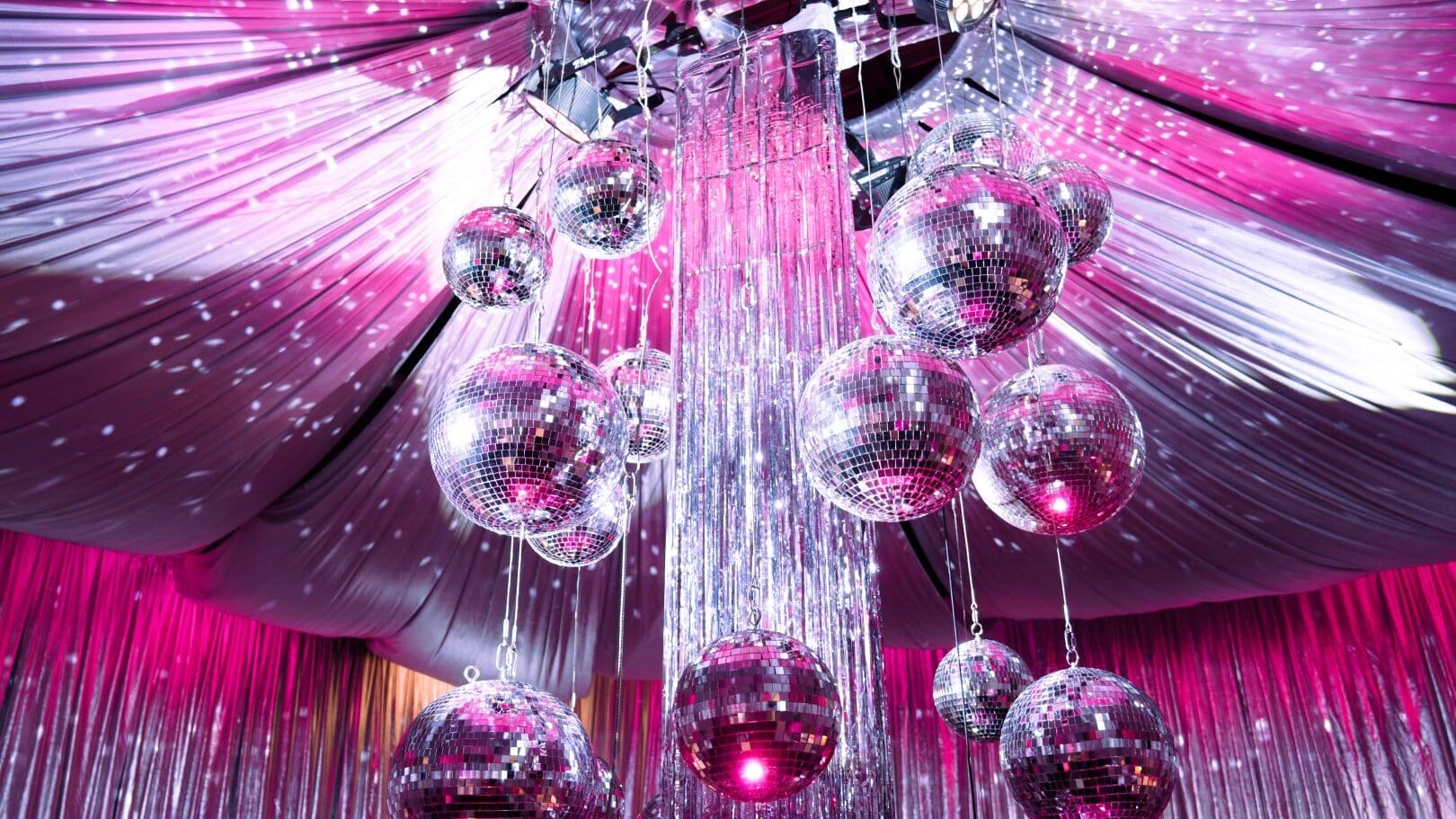 silver mirror balls, silver tinsel, silver drape, pink lighting
