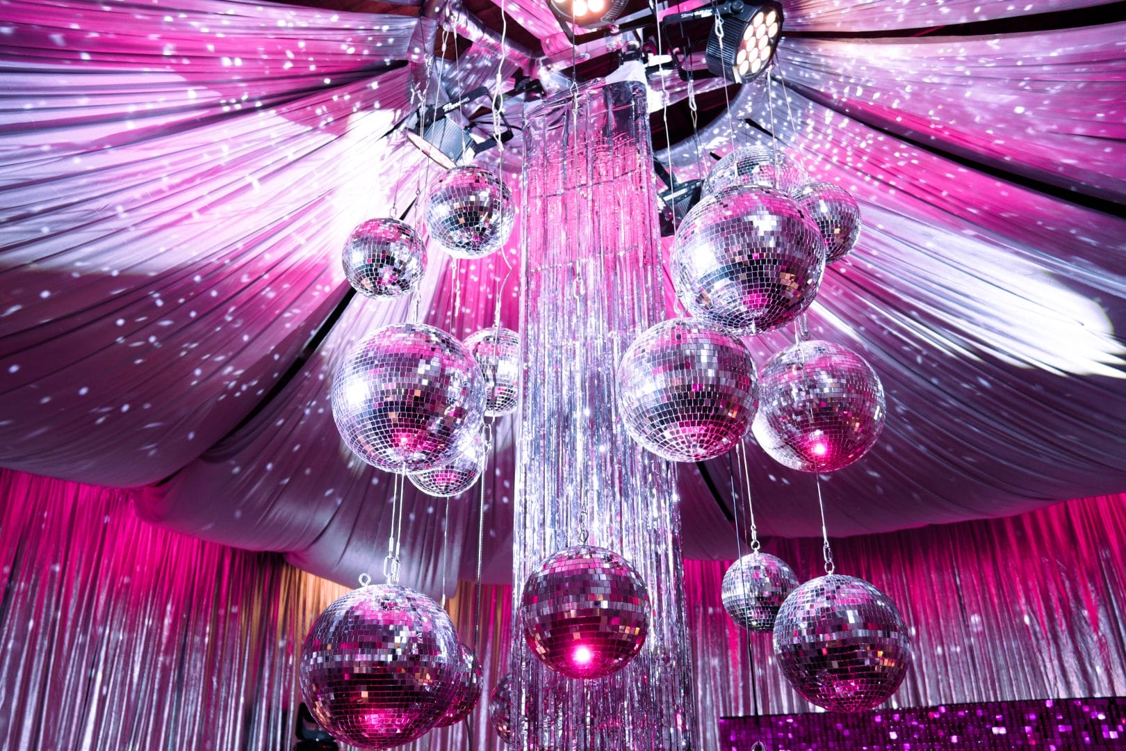 silver mirror balls, silver tinsel, silver drape, pink lighting