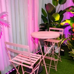 Pink cocktail furniture with greenery and florals in the background