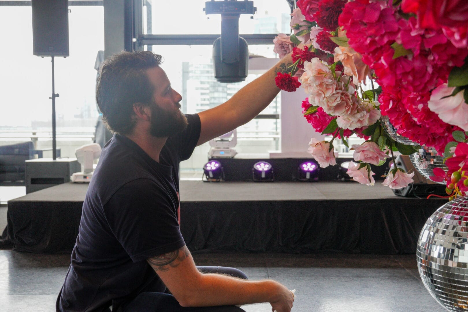Kane adding florals to the pink floral and silver mirror ball ceiling installation